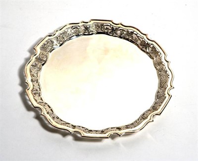 Lot 194 - A shaped circular silver tray, Roberts & Belk, Sheffield 2000, with pierced fruiting vine...