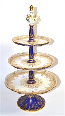 Lot 223 - A Continental porcelain three-tier cake stand, the top with gilt decoration and the undersides,...