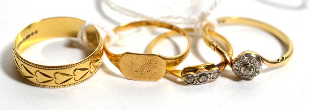 Lot 235 - An 18ct gold band ring, an 18ct gold signet ring, an 18ct gold three stone ring and an 18ct...