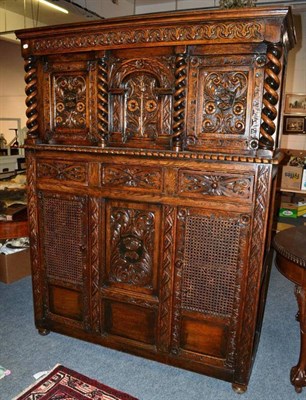 Lot 1149 - A reproduction oak carved court cupboard