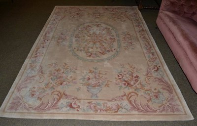 Lot 1159 - Savonnerie style carpet, China, The camel field with oval central panel enclosed by floral borders
