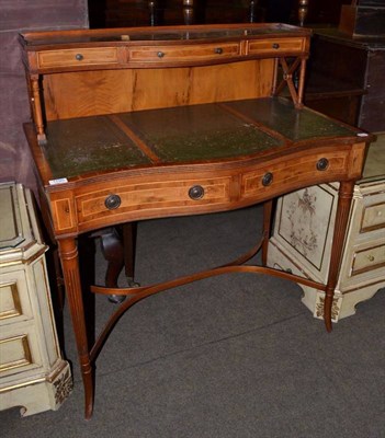 Lot 1195 - A reproduction yew wood and leather topped serpentine shaped writing table, with two drawers,...