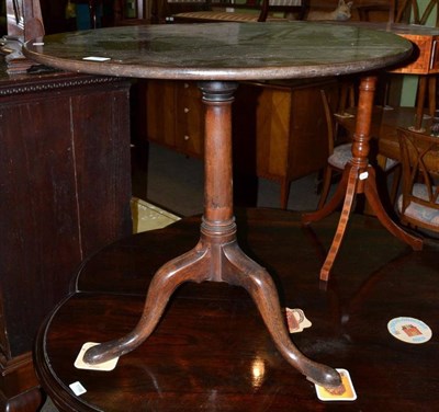 Lot 1197 - A mahogany tripod table, 18th century in part, with circular fliptop on a gun barrel support...