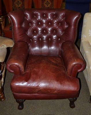 Lot 1233 - A feather filled brown leather armchair with carved claw and ball feet, 82cm wide