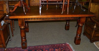 Lot 1242 - A reproduction joined oak rectangular dining table with cleated ends and turned block legs,...