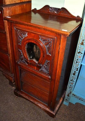 Lot 1260 - A late Victorian walnut music cabinet, the carved door in the form of a horseshoe