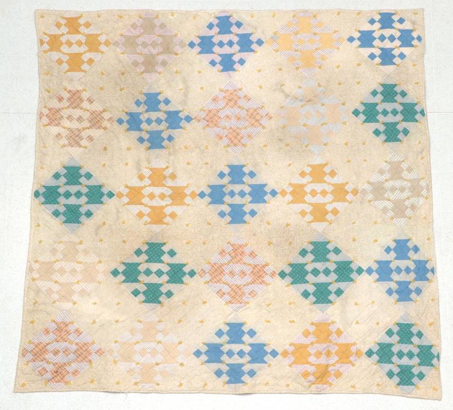 Lot 2009 - An Early 20th Century Patchwork Quilt, on a yellow cotton ground printed with trellis and...