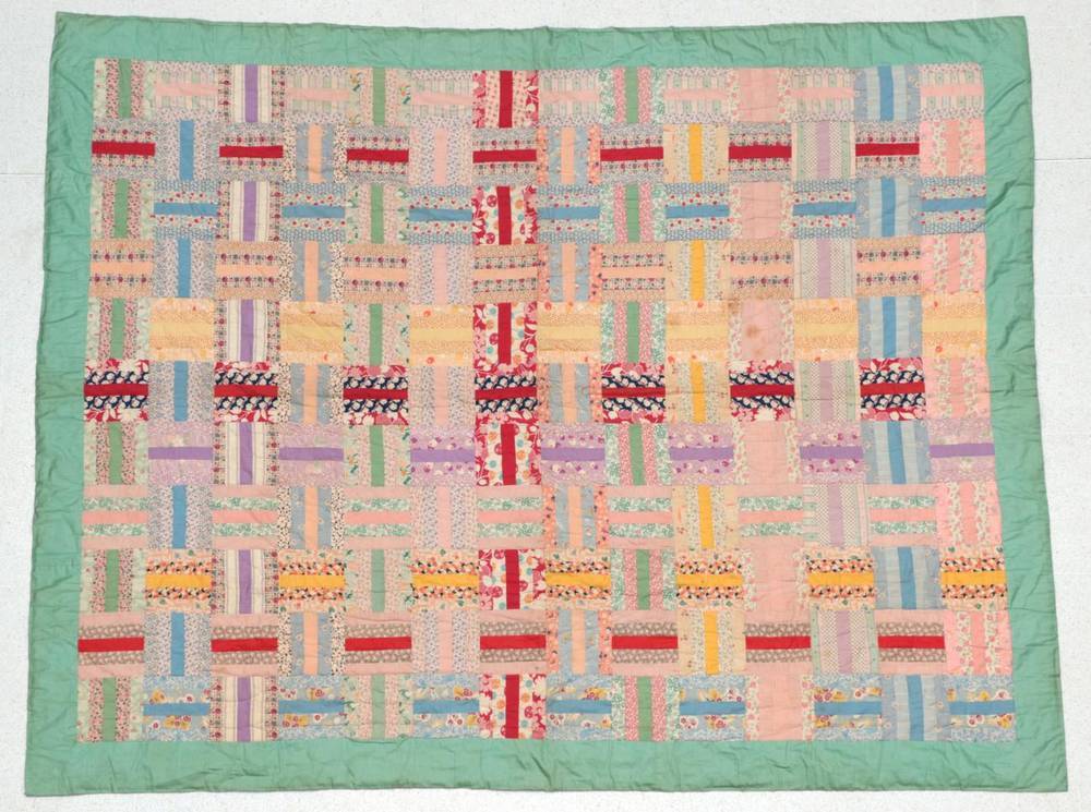 Lot 2010 - Circa 1930s Log Cabin Pattern Quilt, in colourful printed cottons, with pale green border and cream