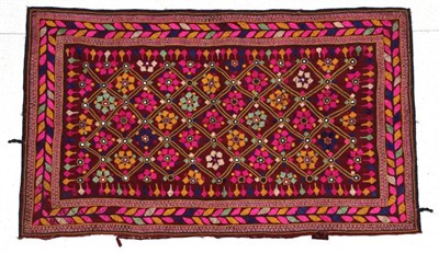 Lot 2153 - A Decorative Indian Wedding Rug, on a red cotton ground embroidered with a trellis design...