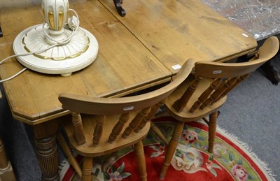 Lot 1115 - A pine farmhouse kitchen table and four chairs