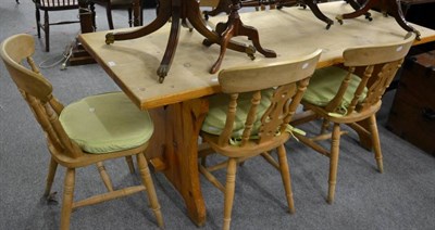 Lot 1120 - A pine farmhouse kitchen table with trestle base and five similar chairs (6)