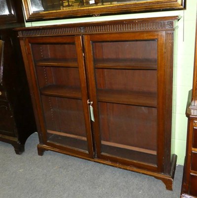 Lot 1192 - A glazed bookcase and an oak 1920s drop leaf table (2)