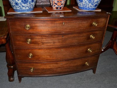 Lot 1228 - A mahogany bowfront chest of drawers, early 19th century, the reeded edge above four graduated long