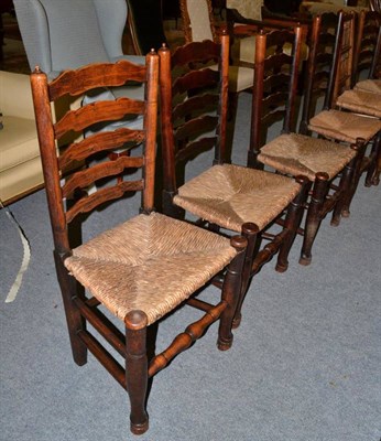 Lot 1248 - A set of five rush seated ladder back chairs, together with an oak spindle back chair (6)