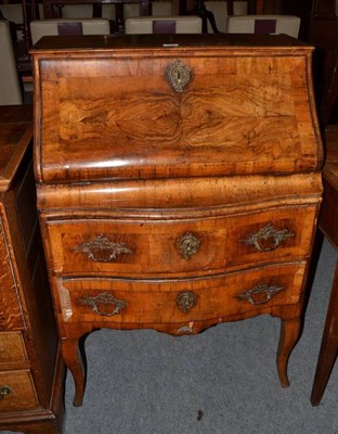 Lot 1257 - A gilt metal mounted and crossbanded walnut bureau of serpentine shape, with fall front and...