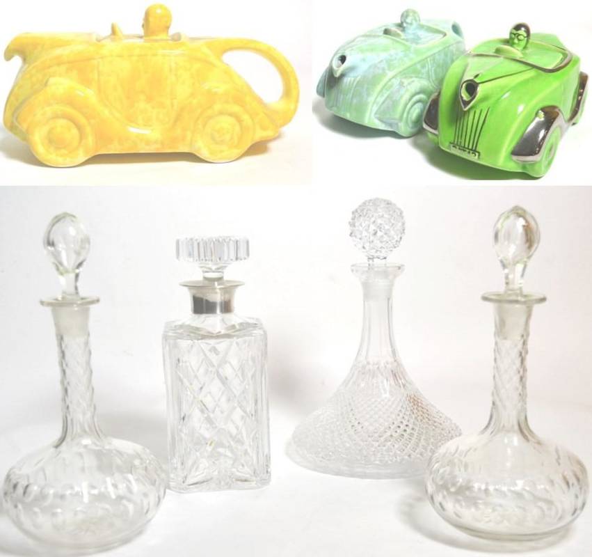 Lot 33 - A silver collared glass decanter; three other decanters and three Sadler racing car form teapots