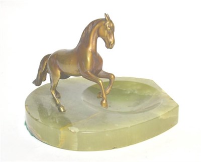 Lot 47 - An onyx ashtray mounted with a patinated model of a horse