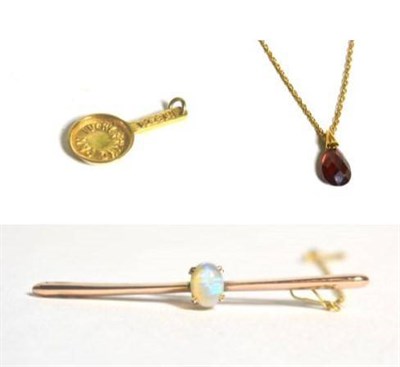 Lot 72 - An opal bar brooch, a 9 carat gold 'LUCKY FRYING PAN' charm, and a garnet pendant on 9 carat...