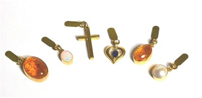 Lot 86 - An opal pendant, a mabe pearl pendant, a sapphire pendant, a cross pendant and two amber pendants