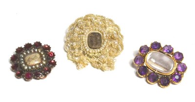 Lot 109 - A garnet and seed pearl mourning brooch, an amethyst mourning brooch and a seed pearl mourning...