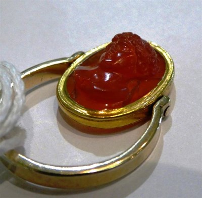 Lot 228 - A carved carnelian cameo mounted swivel ring, carved in high relief depicting the bust of...