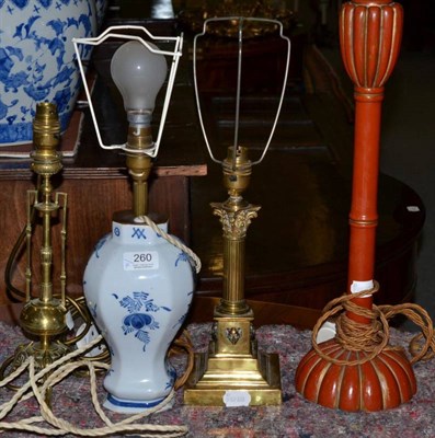 Lot 260 - Four various table lamps comprising two brass examples, a blue and white Delft example and a...