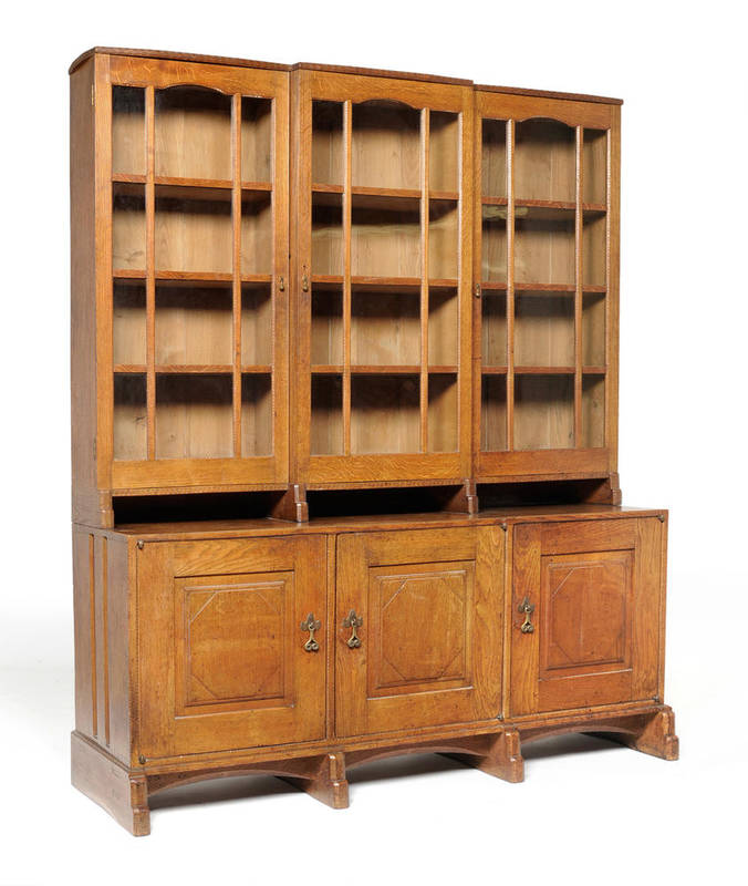 Lot 1929 - Sidney Barnsley (1865-1926) An Oak Glazed Bookcase, circa 1921, the upper section decorated...