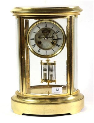 Lot 42 - An oval shaped brass four glass mantel clock, circa 1890, bevelled glass panels, 4-1/2-inch...