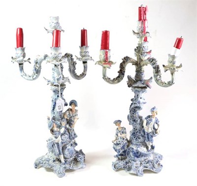 Lot 63 - A pair of late 19th century blue and white Continental four-light candelabra with figural and...