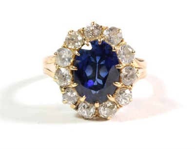 Lot 95 - A synthetic sapphire and diamond cluster ring, an oval cut synthetic sapphire in a claw...