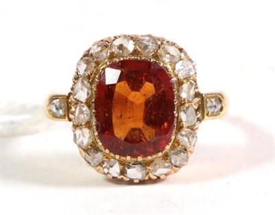 Lot 107 - An 18 carat gold hessonite garnet and diamond cluster ring, a cushion cut hessonite garnet in a...