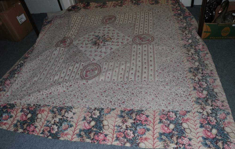 Lot 1038 - A 19th century large patchwork quilt with floral printed fabrics and a central posy, within a...