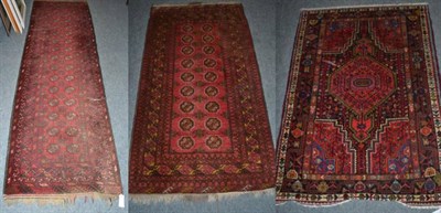 Lot 1243 - Three red ground rugs with central medallion designs (3)