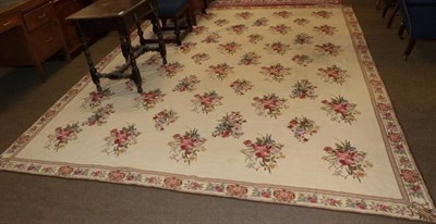 Lot 1247 - A Chinese needlepoint carpet, the ivory ground of naturalistic floral sprays enclosed by narrow...