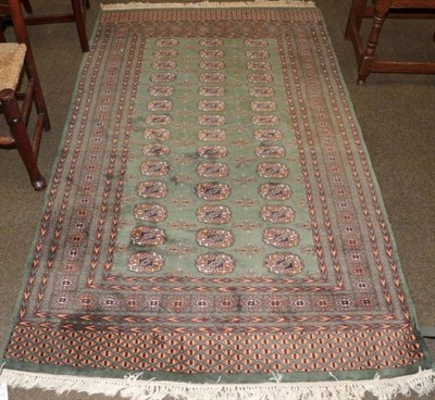 Lot 1250 - Lahore Bukhara rug, Pakistan, the apple green field with rows of guls enclosed by multiple borders