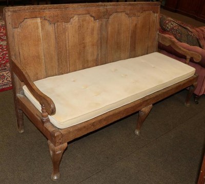 Lot 1311 - A George III joined oak panel-back settle, early 19th century, with four moulded panels above a...