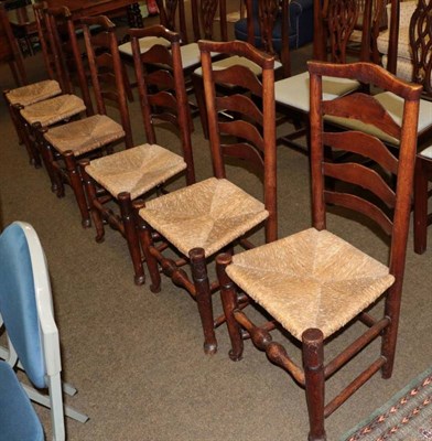 Lot 1325 - A set of six oak ladder back rush seated dining chairs