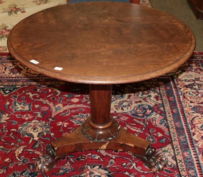 Lot 1334 - An early 19th century and later mahogany tilt top tripod table, with lion claw feet