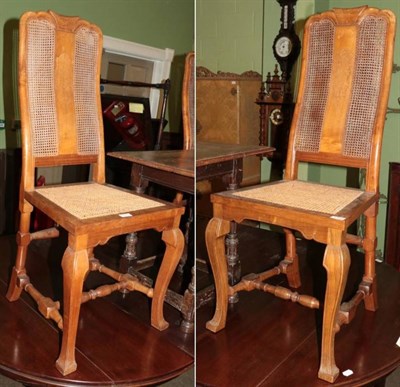 Lot 1352 - A pair of walnut hall chairs, each with caned seats to the backs and with pokerwork splat