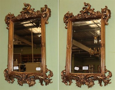 Lot 1366 - A pair of modern gilt scroll decorated wall mirrors