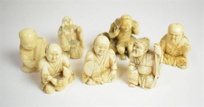 Lot 36 - A small Japanese ivory Okimono, Meiji period, carved as a man seated beside a basket with gourd...
