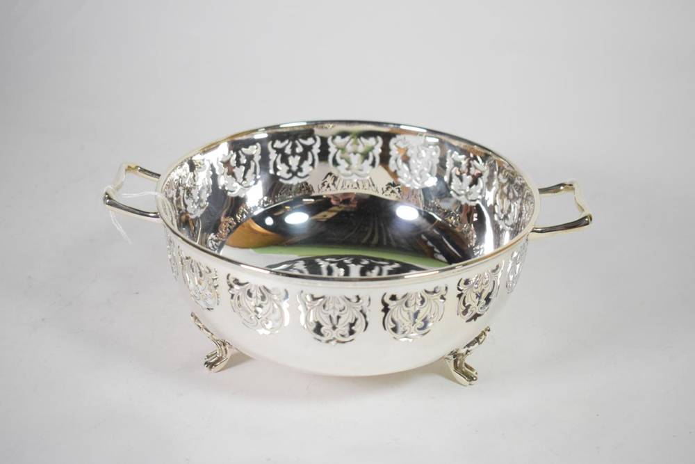 Lot 67 - A twin handled silver bowl, S J Levi & Co, Birmingham 1931, with a periced folaite border on...