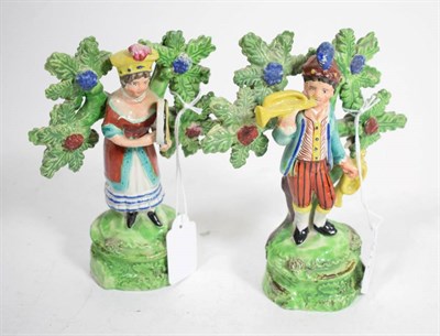 Lot 115 - A pair of Walton type pearlware figures of musicians, early 19th century, he holding trumpets,...