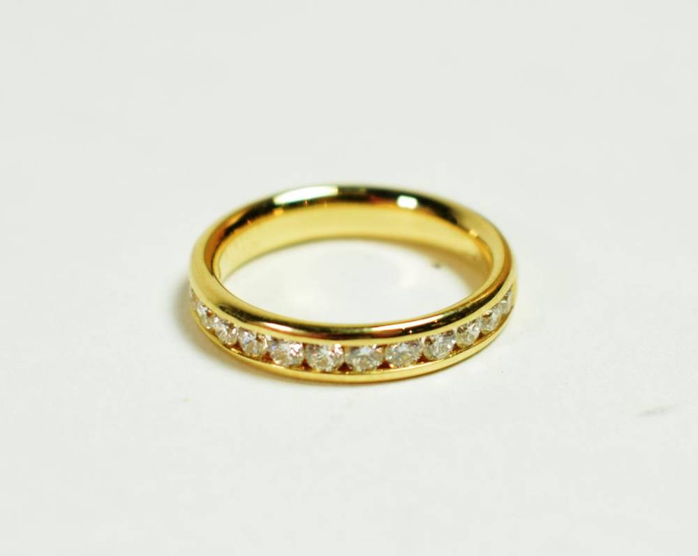 Lot 211 - An 18 carat gold channel set diamond half hoop ring, total estimated diamond weight 0.65 carat...
