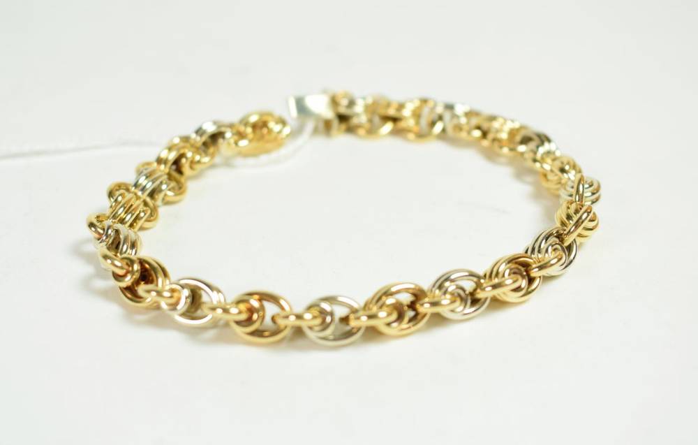 Lot 214 - An 18 carat two colour gold fancy link bracelet with sapphire set clasp, length 19cm