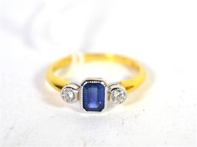 Lot 225 - An 18 carat gold sapphire and diamond three stone ring, an emerald cut sapphire spaced by round...