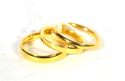 Lot 235 - Three 18 carat gold band rings, finger sizes K, L, and L1/2 (3)