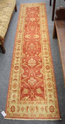 Lot 1153 - Narrow Afghan 'Ziegler' Runner, the soft coral floral lattice field enclosed by cream borders,...