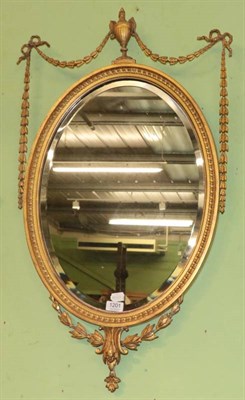 Lot 1201 - A 19th century gilt and gesso bevel glass oval mirror in Adams style