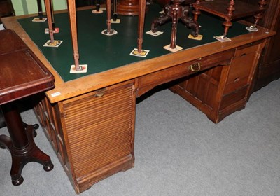 Lot 1216 - An early 20th century oak partners desk with tambour fronted drawers